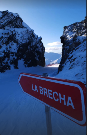 La Brecha en Cerro Castor, Ushuaia: el cartel rojo señala la pista entre dos formaciones rocosas nevadas